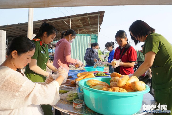 Phát nước và bánh mì cho người dân về miền Tây ăn Tết - Ảnh 3.